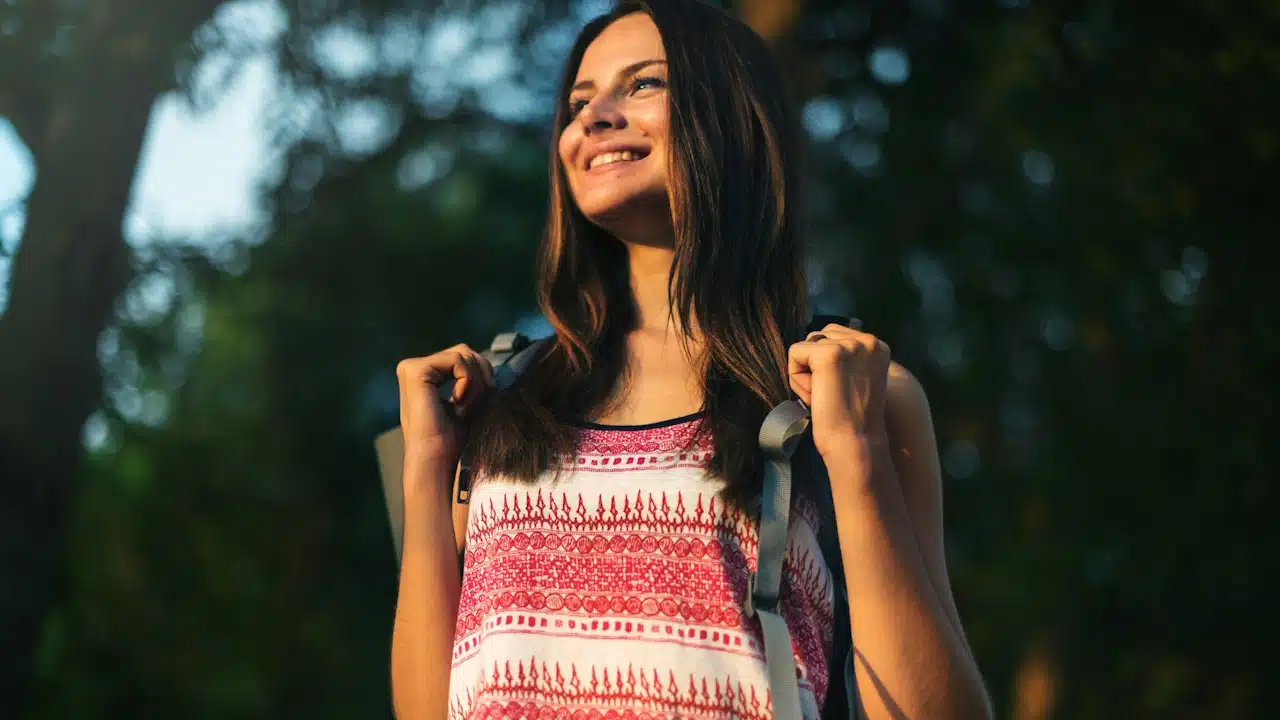 A passionate female traveler wearing a backpack.
