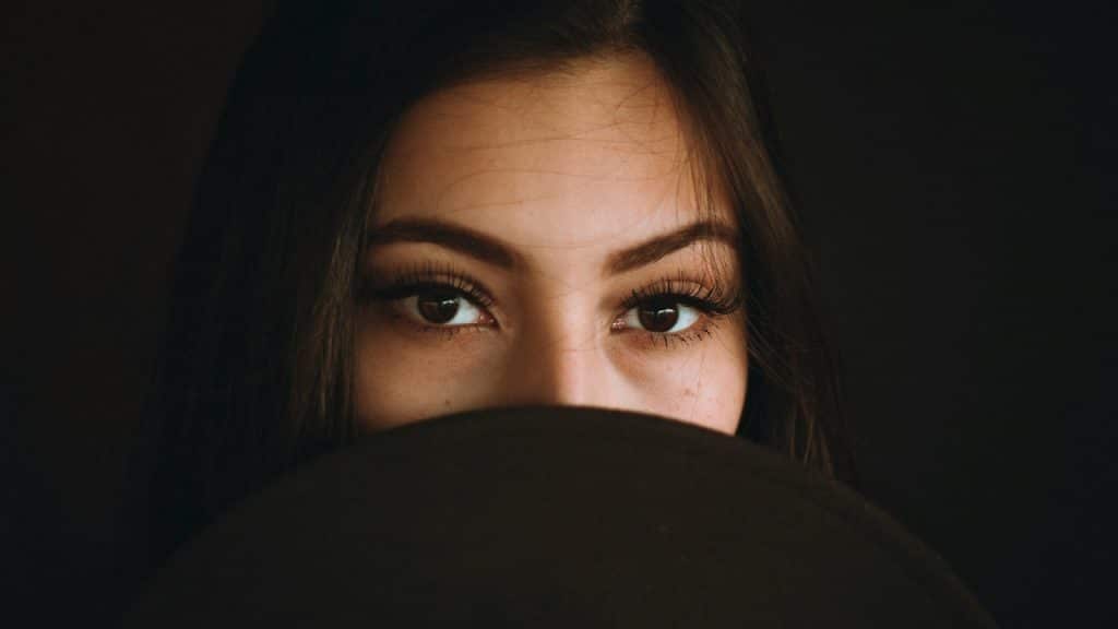 A woman covering her face from nose to mouth.