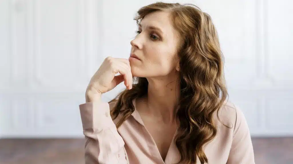 A woman resting her chin on her hand in thought.