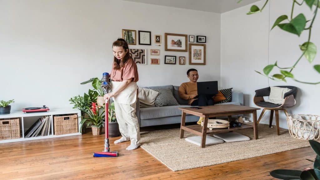 A woman cleans while her husband works