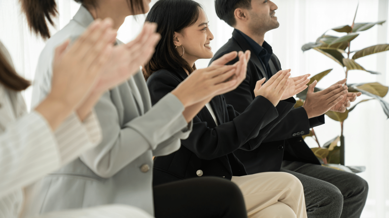 A woman clapping for someone presenting 
