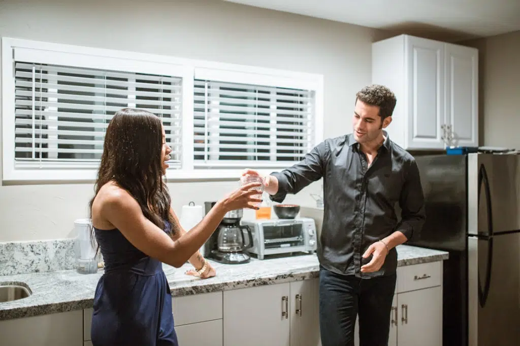 A  couple drinking in the kitchen