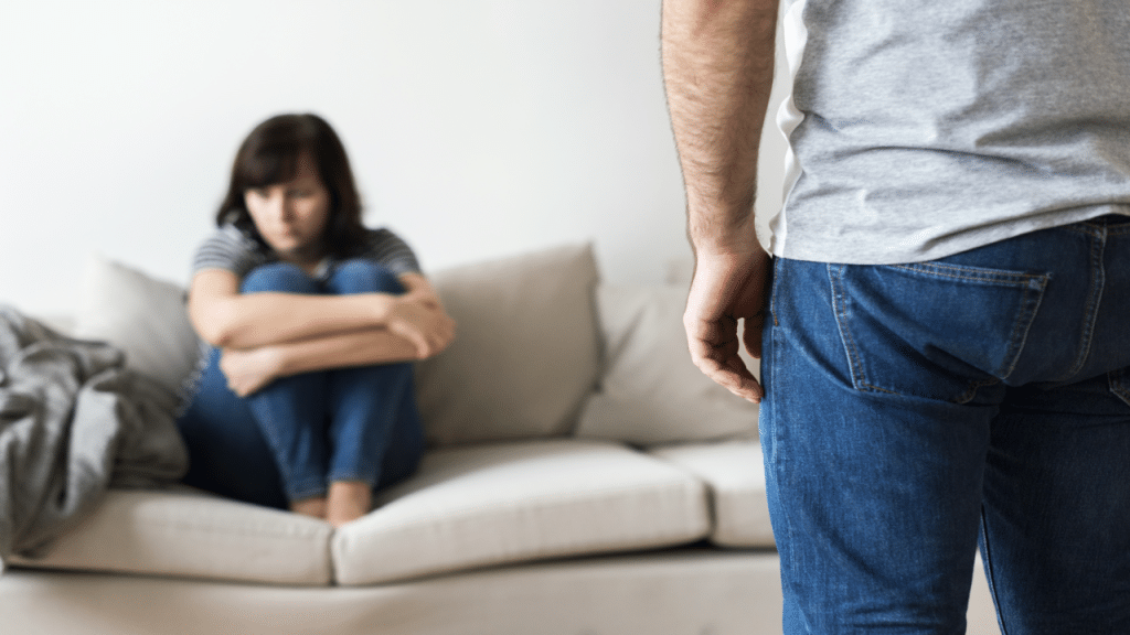 A woman looking upset while her husband berates her