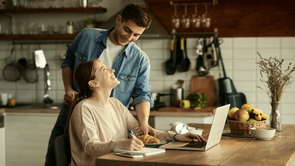 A man feeding his wife while she works
