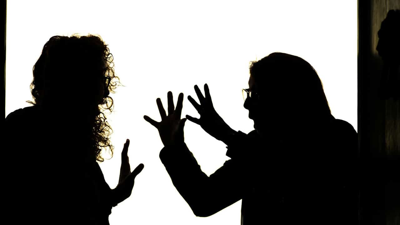 Silhouetted figures engage in a heated argument.