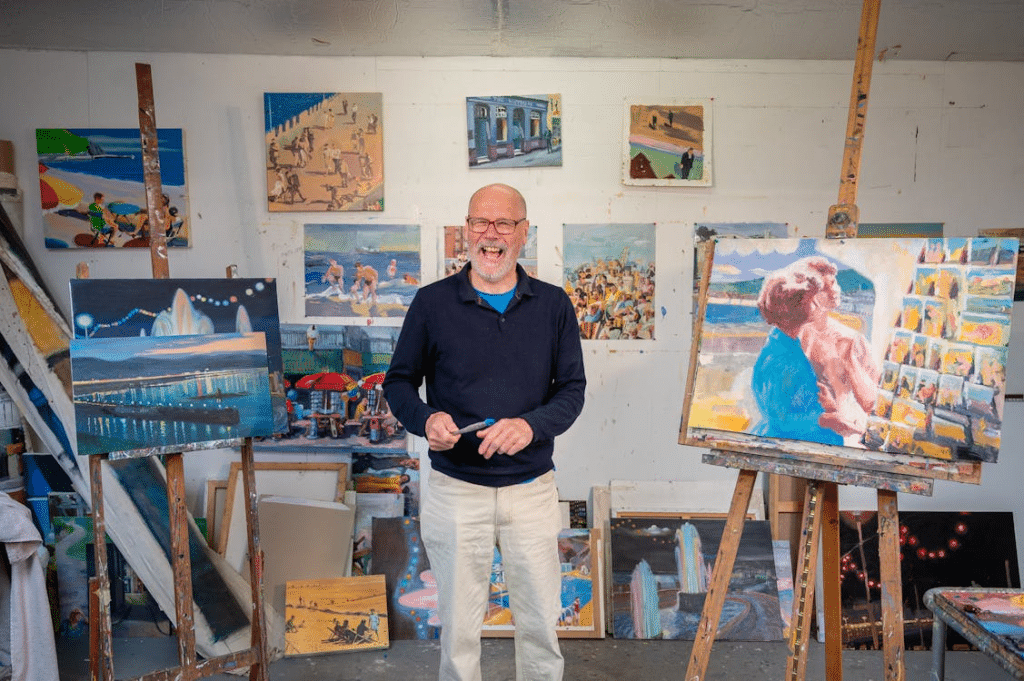 An man standing in room with paintings