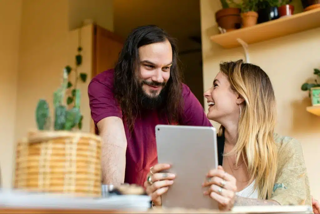A man and woman looking at the tablet