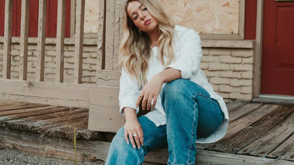 A woman sitting on wooden steps looking at the camera.