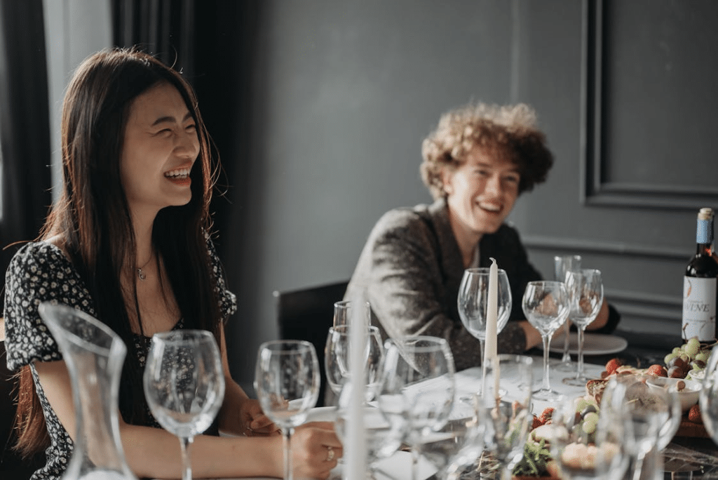 Woman in Black and White Floral Dress Smiling while Sitting Down