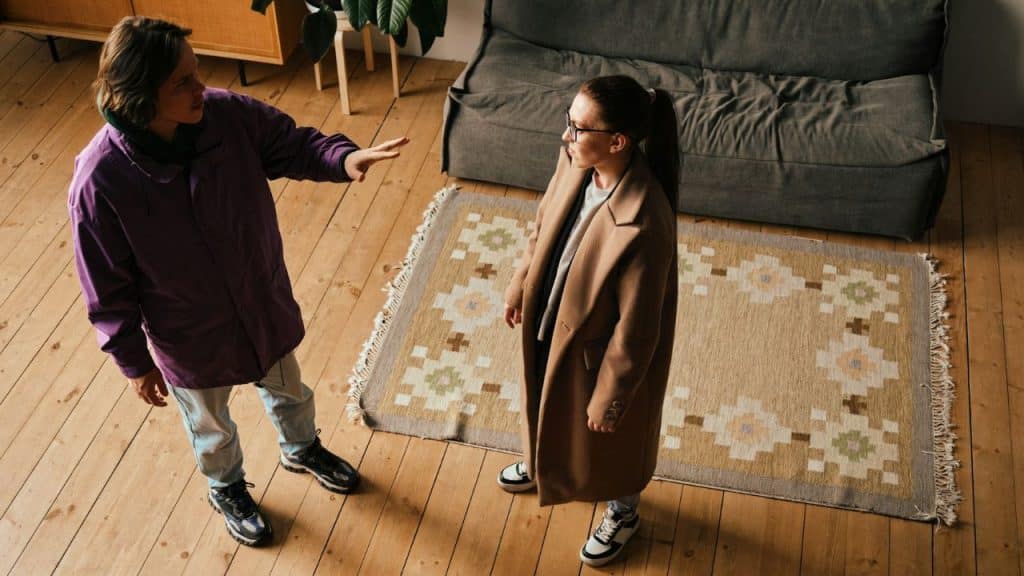 Overhead view of two people standing in a room, arguing or having a serious conversation.
