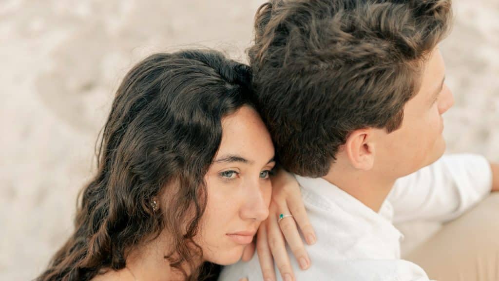 A man and a woman are sitting on a beach.
