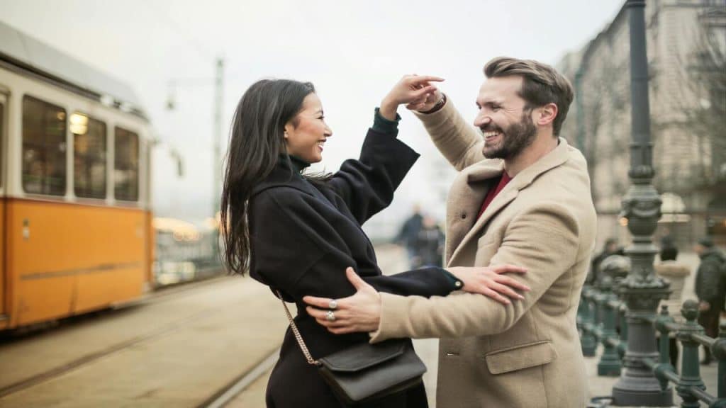 A couple dancing on a sidewalk
