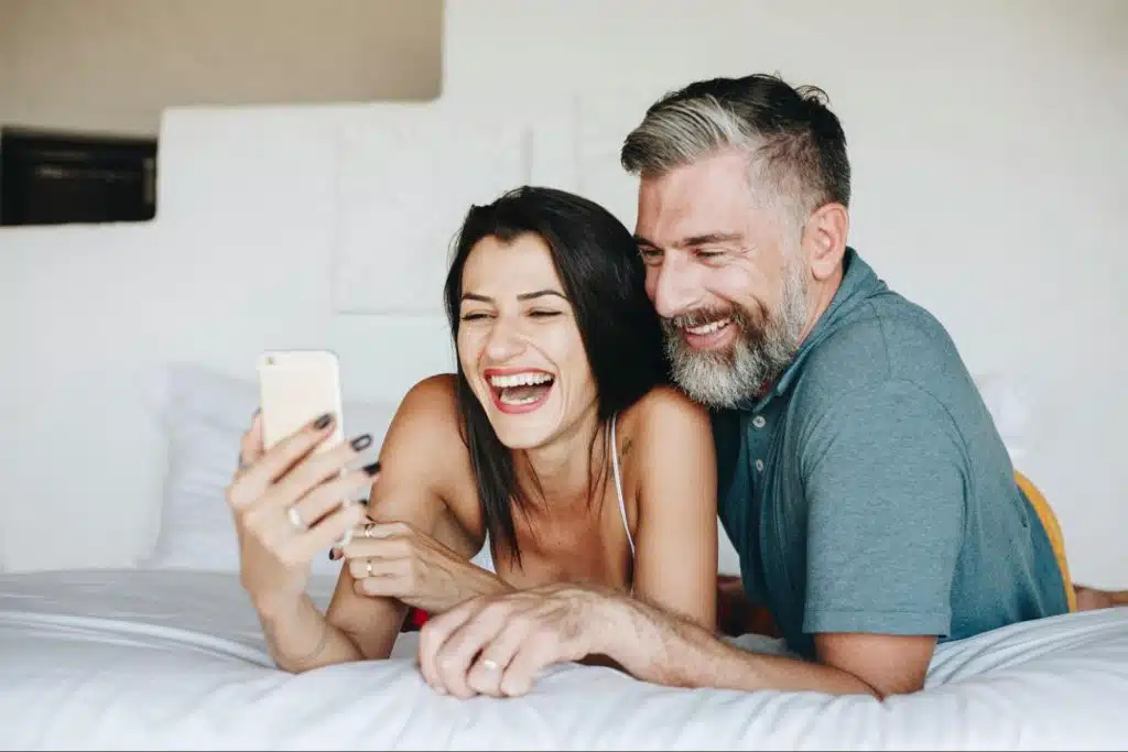 A man and woman looking at the phone