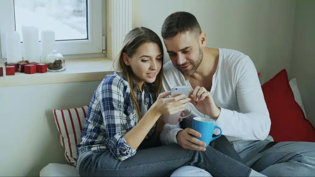 A man and woman looking at the phone
