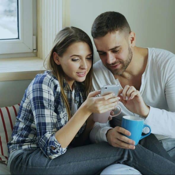 A man and woman looking at the phone