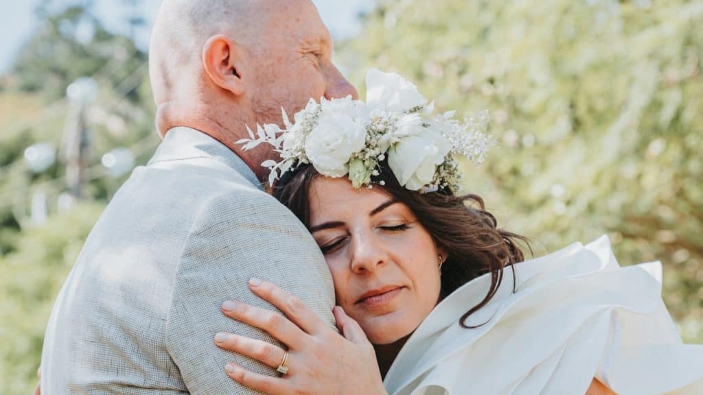 A bride and a groom embracing each other.