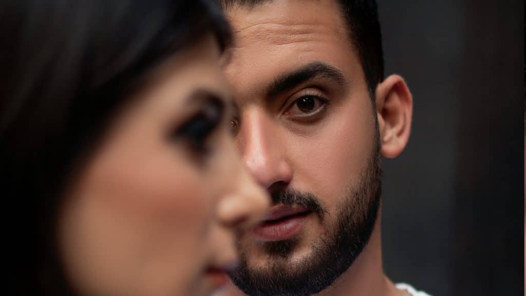 A bearded man looking at a woman.