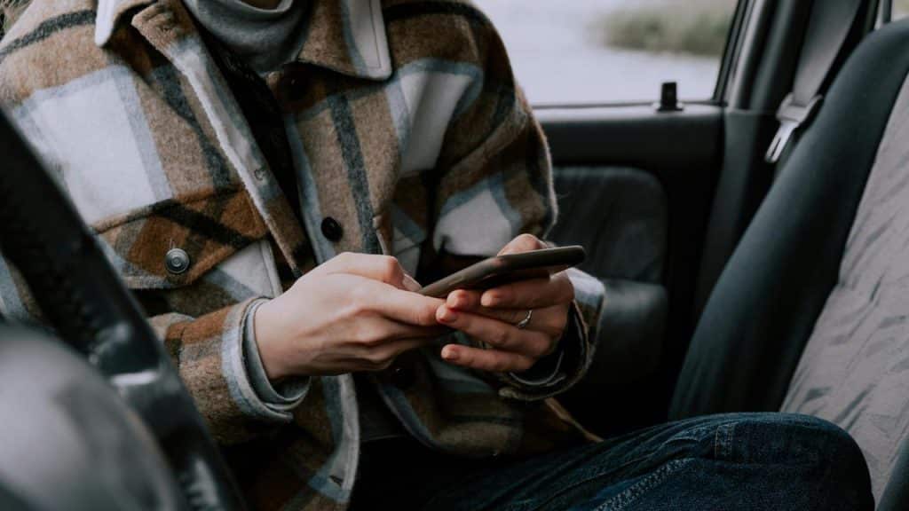 A person sitting in a car using their phone.