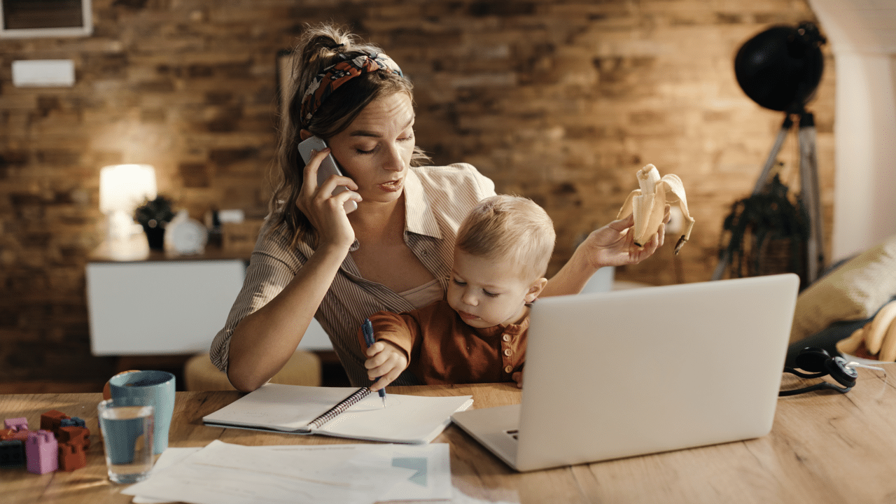 A woman working while taking care of her son
