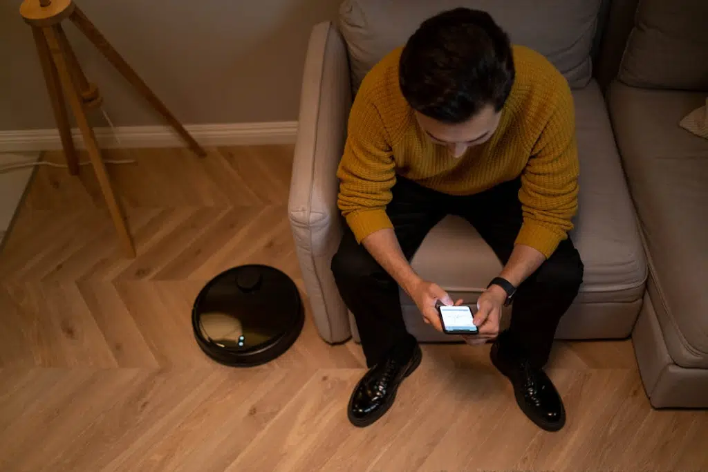 A man sitting on a sofa while holding a phone