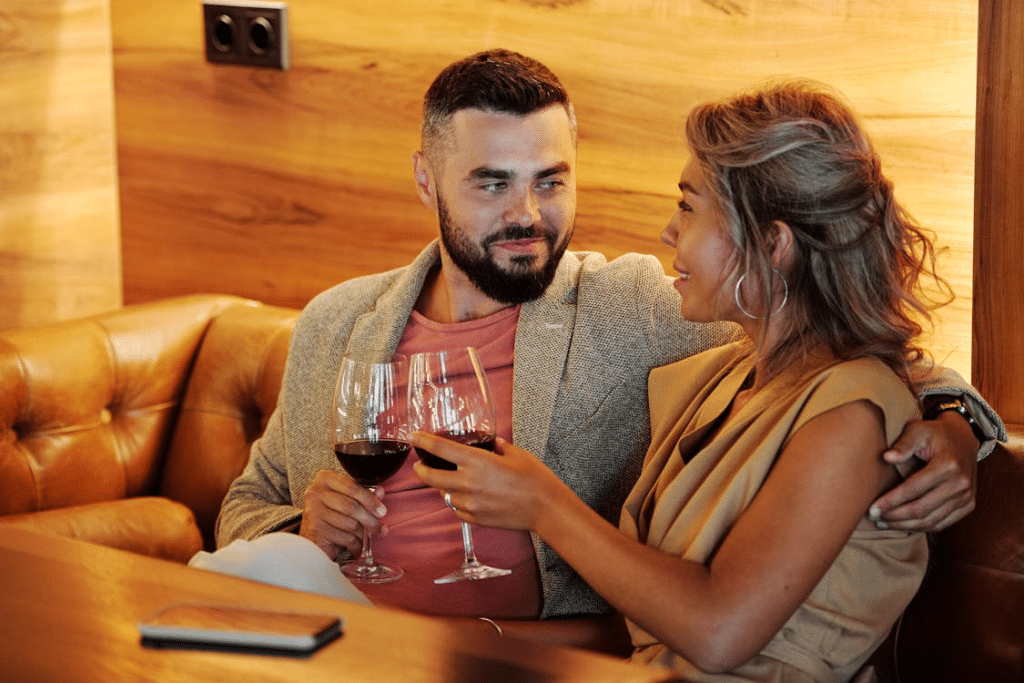 A couple sitting and holding glasses of wine