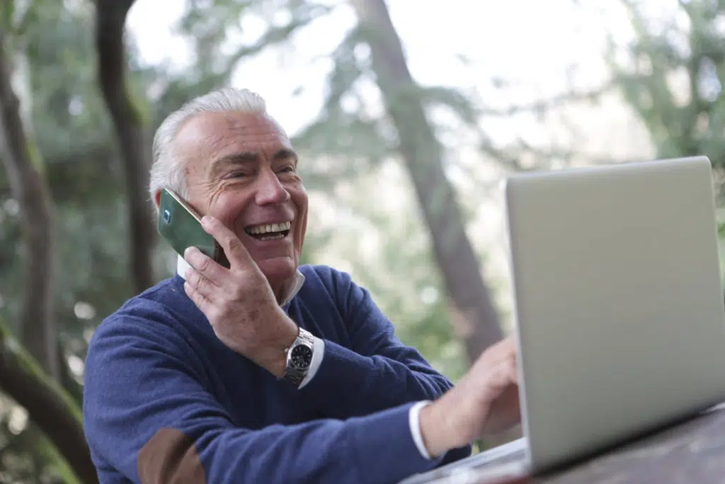 A man using a phone and a laptop