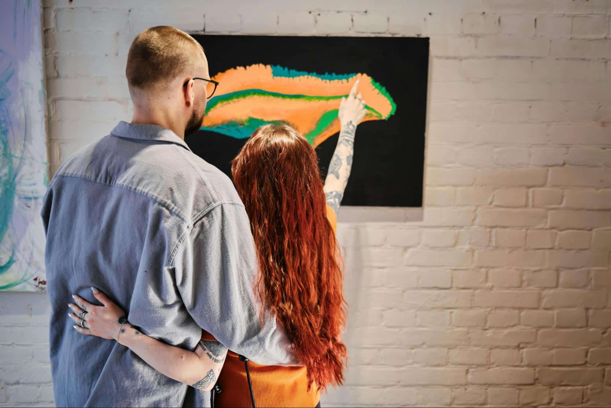 A man and woman looking at the painting