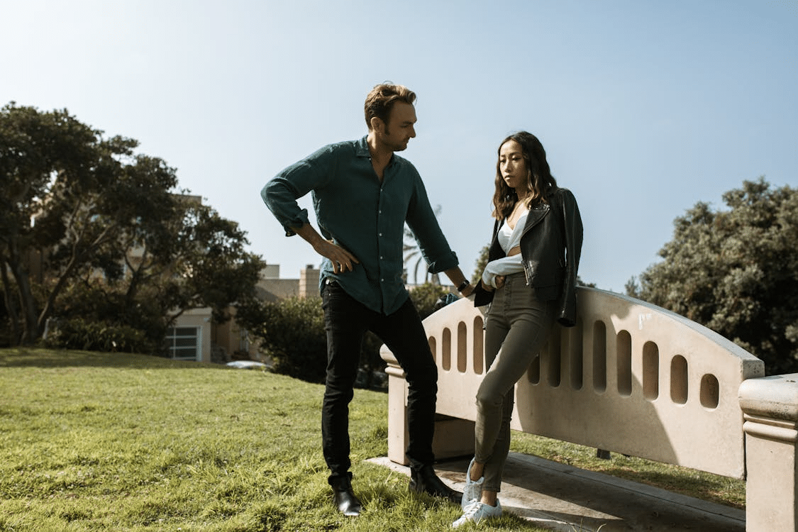 An upset woman standing next to a man