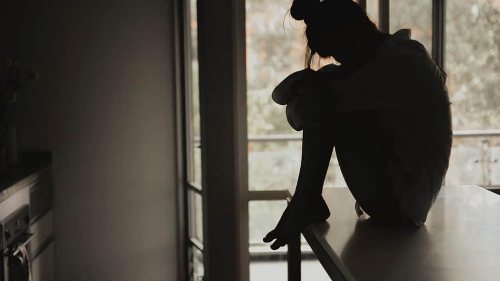 A silhouette of a woman sitting on a countertop.