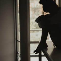 A silhouette of a woman sitting on a countertop.