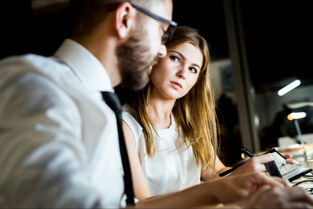 A man checking on a woman;s work