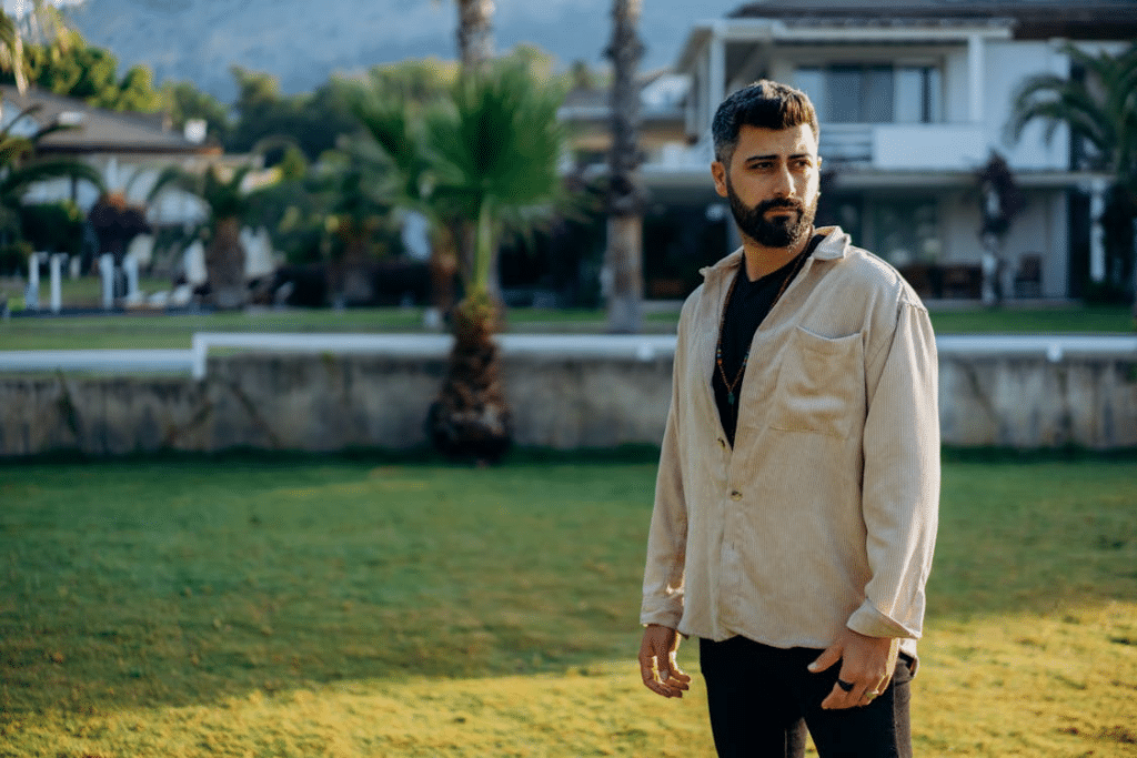 Bearded Man Standing on Green Grass Field