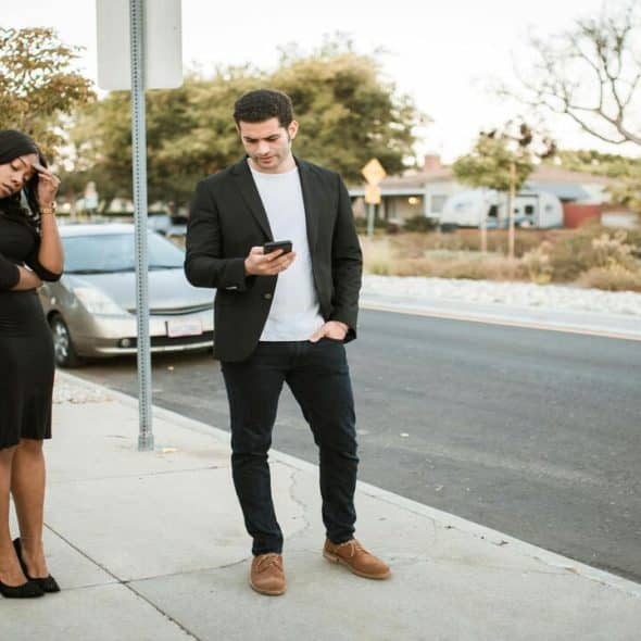 A couple fighting on the sidewalk