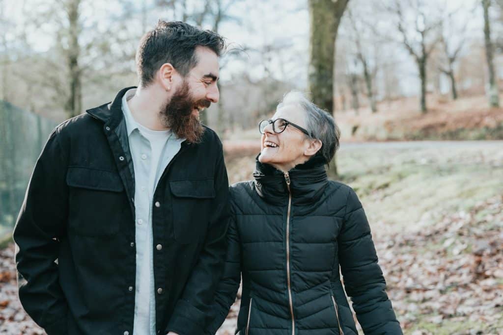 A man and a woman walking through the woods