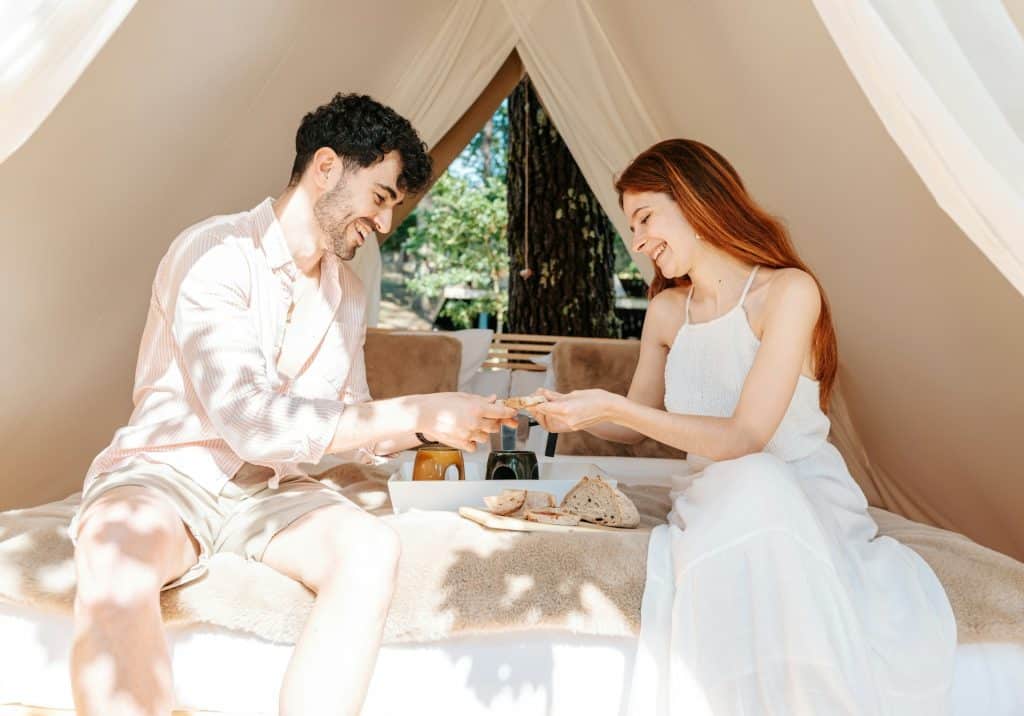 A man and woman sitting in a tent.