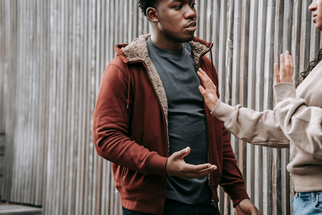 Crop multiethnic couple arguing on street
