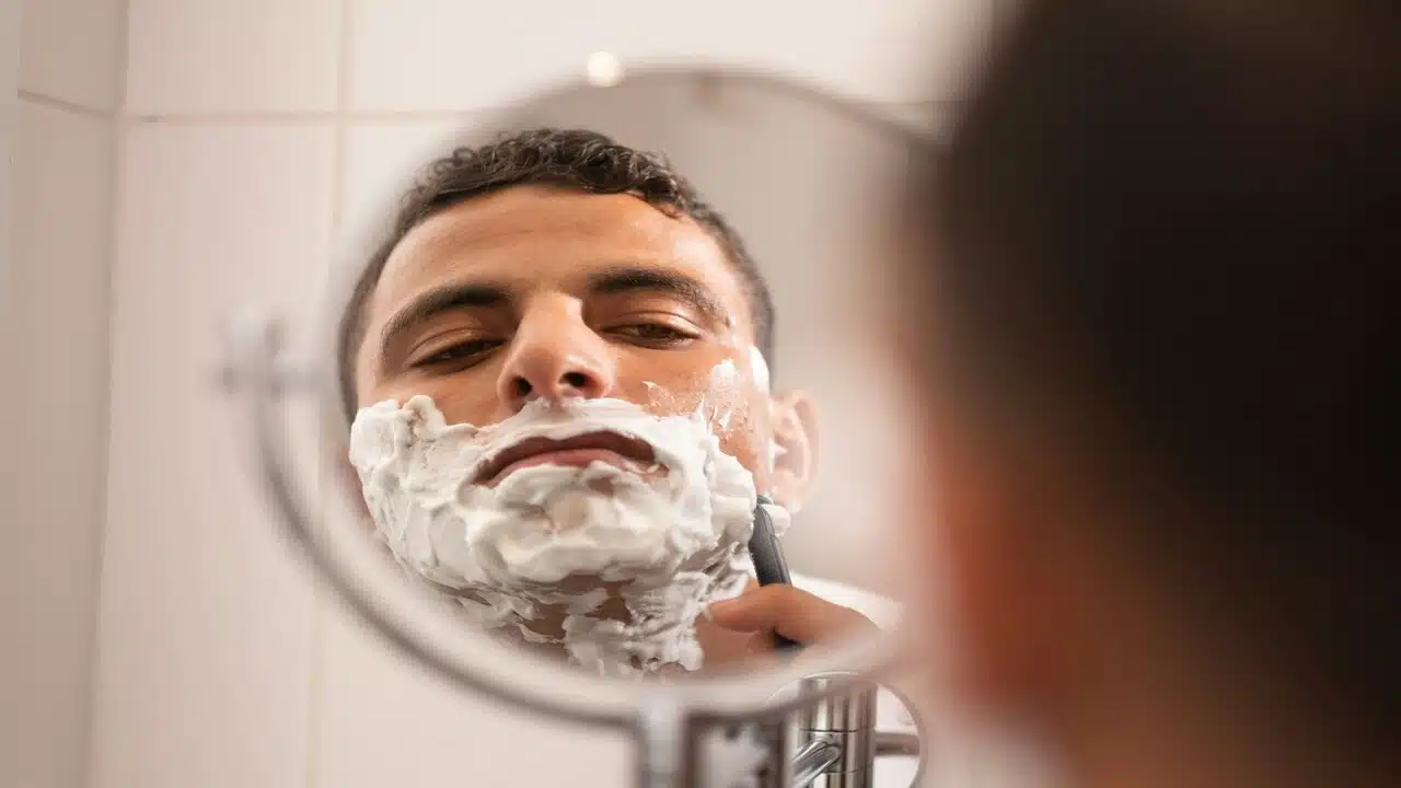 A man shaving in front of a mirror