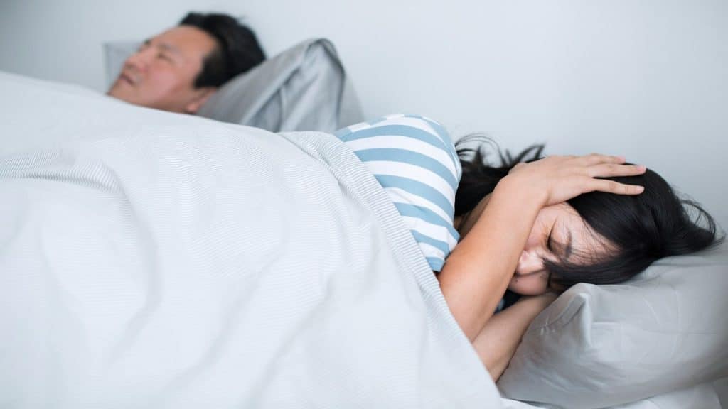 A woman unable to sleep due to her husband’s snoring