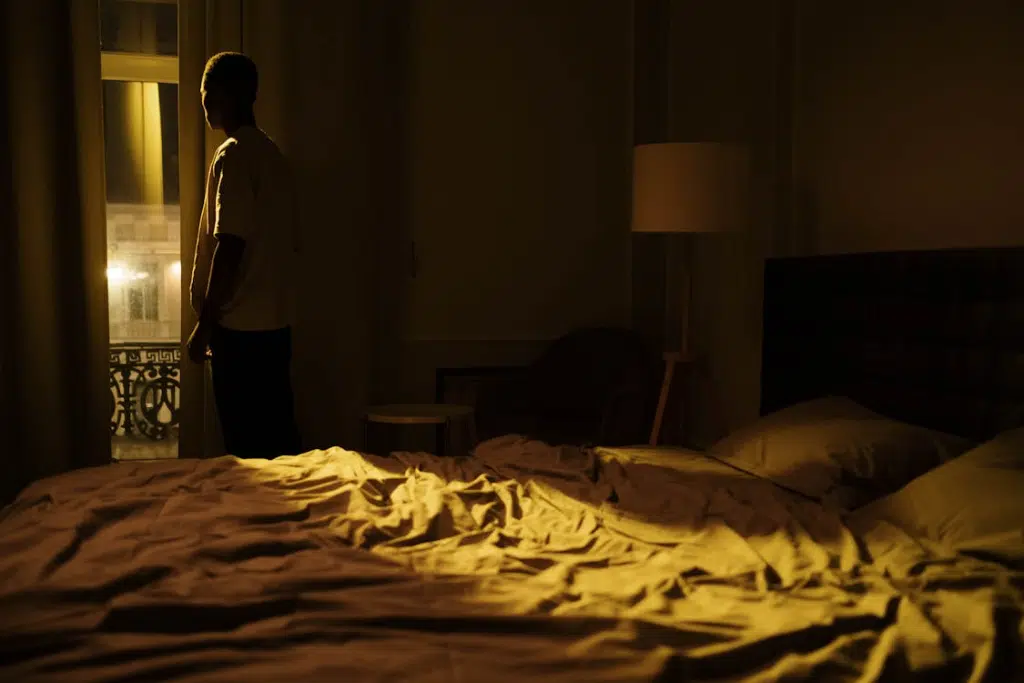 A man standing by the window in the bedroom
