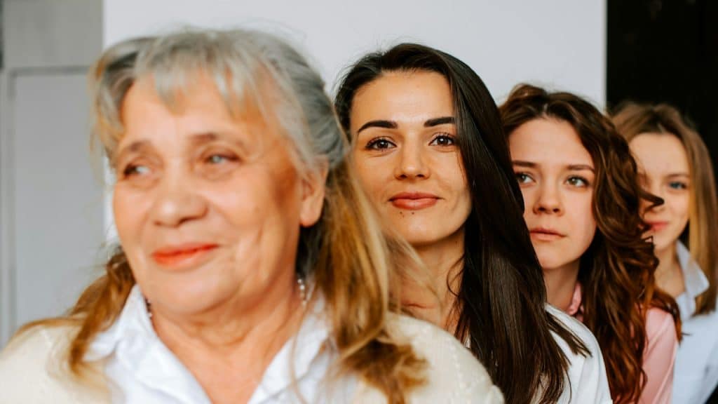 An elderly woman standing with three young women.