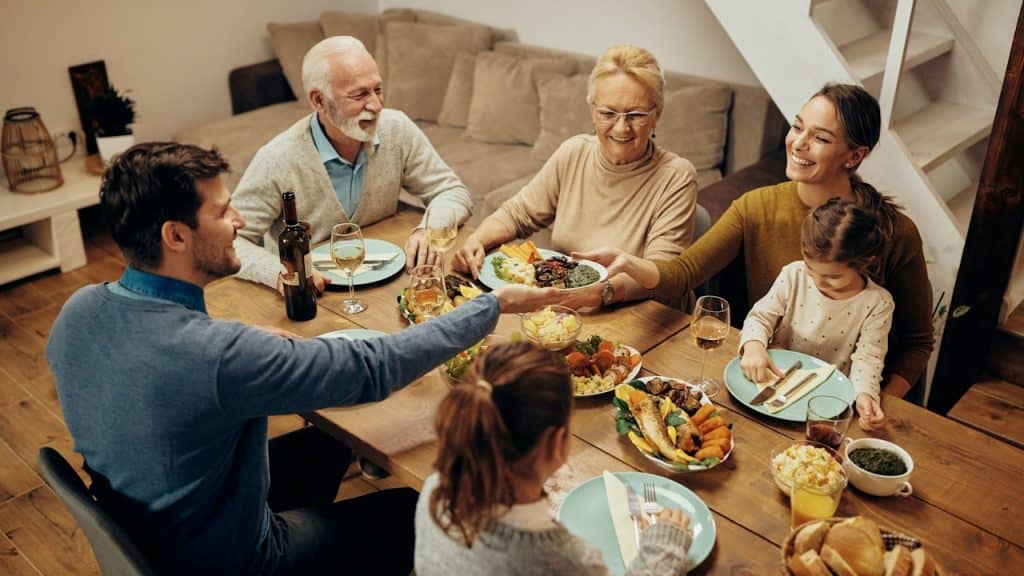 Happy extended family having dinner at the dining table at home.