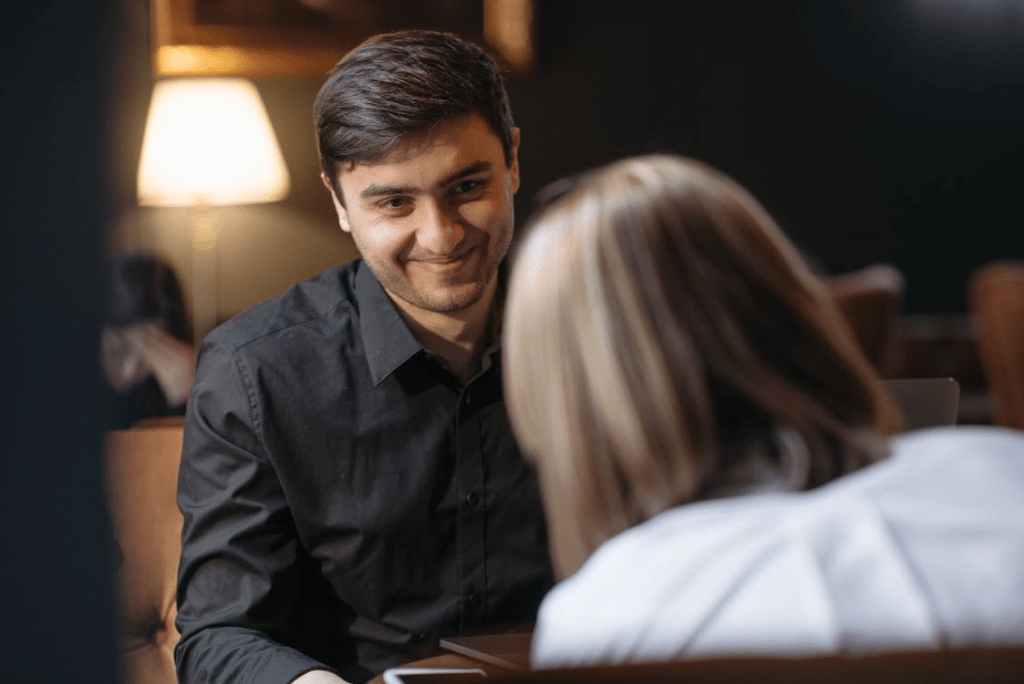 Man in Black Long Sleeve Shirt looking into the eyes of partner across him