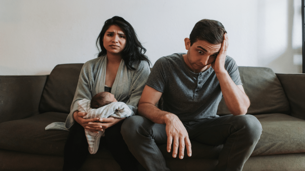 A couple with a newborn looking stressed