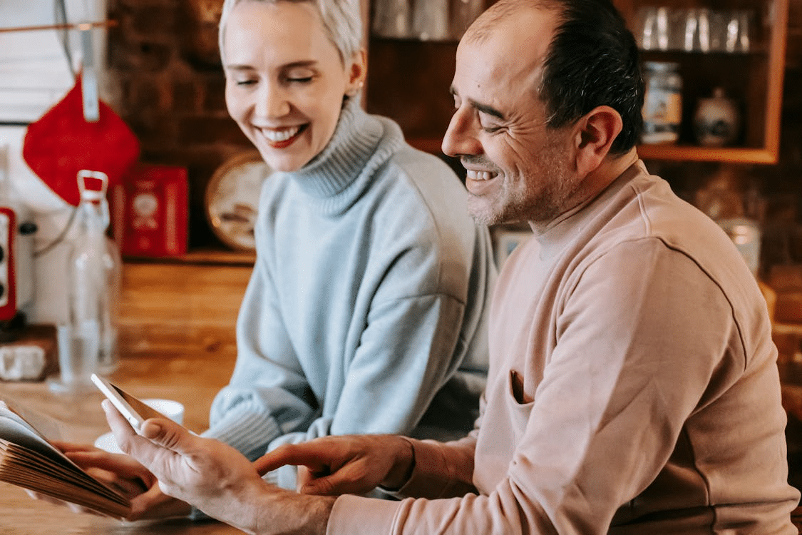 A couple smiling while looking at the tablet