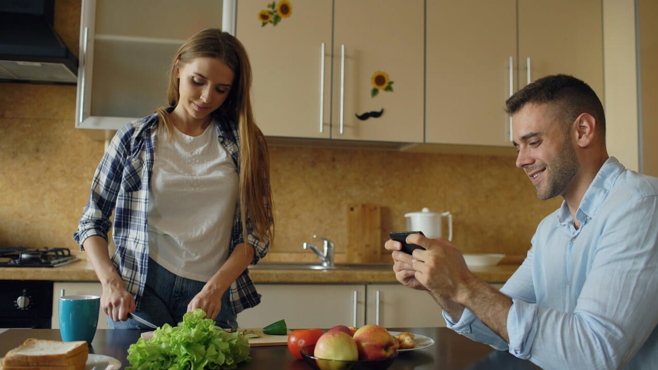 A couple doing their own thing in the kitchen 