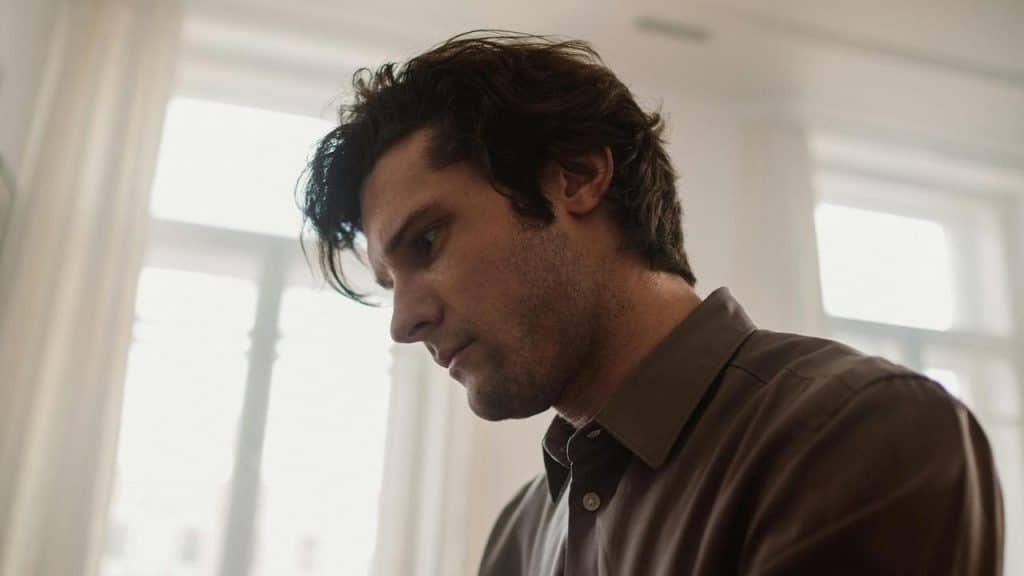 A man looking down with a thoughtful expression.