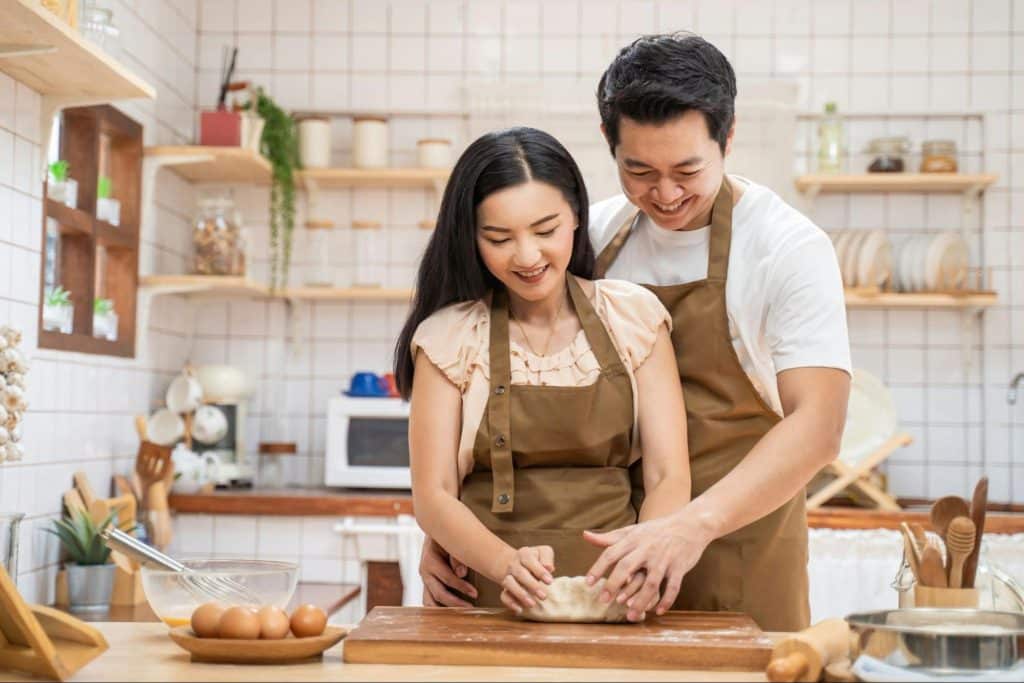 A man helping a woman to bake
