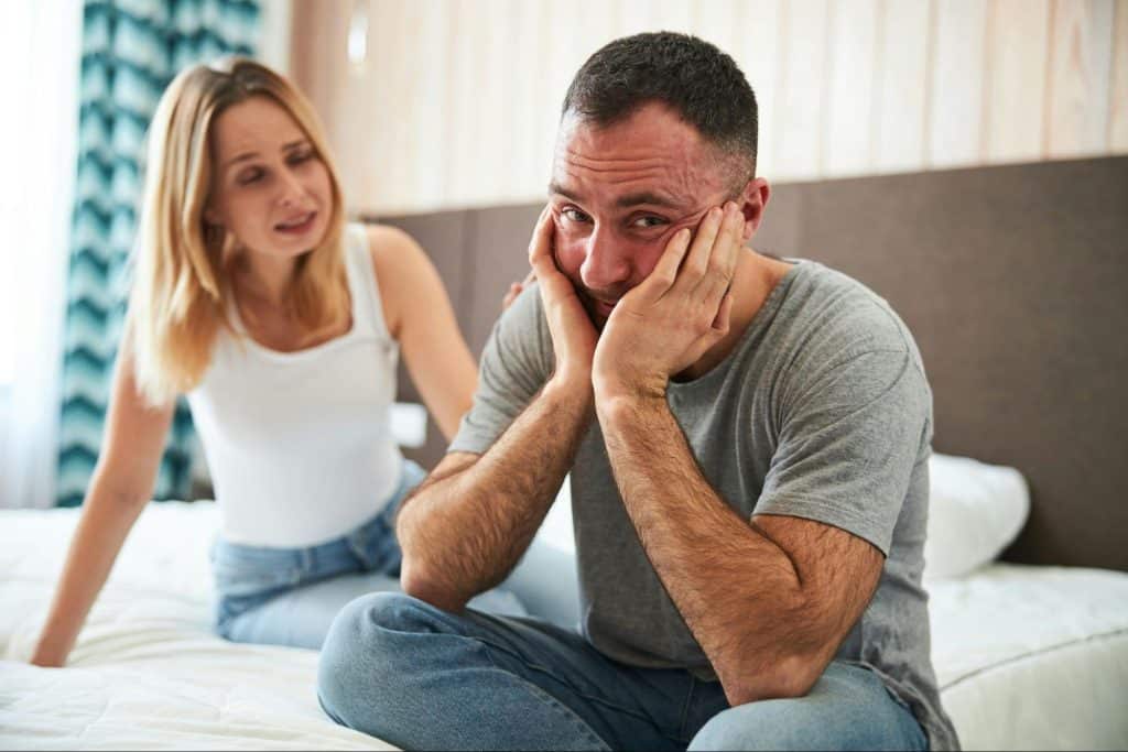 A woman reaching a man’s shoulder