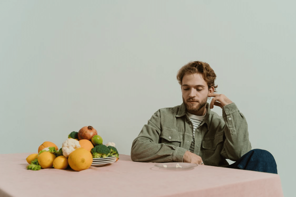A Bearded Man in Corduroy Jacket Looking at the Table with Vegetables