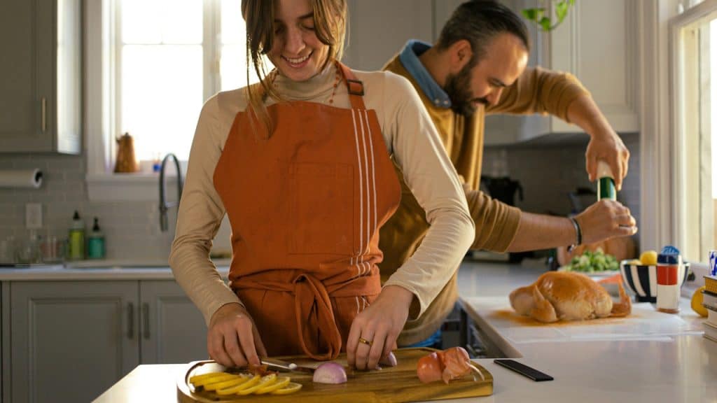 A husband and wife making a meal together.